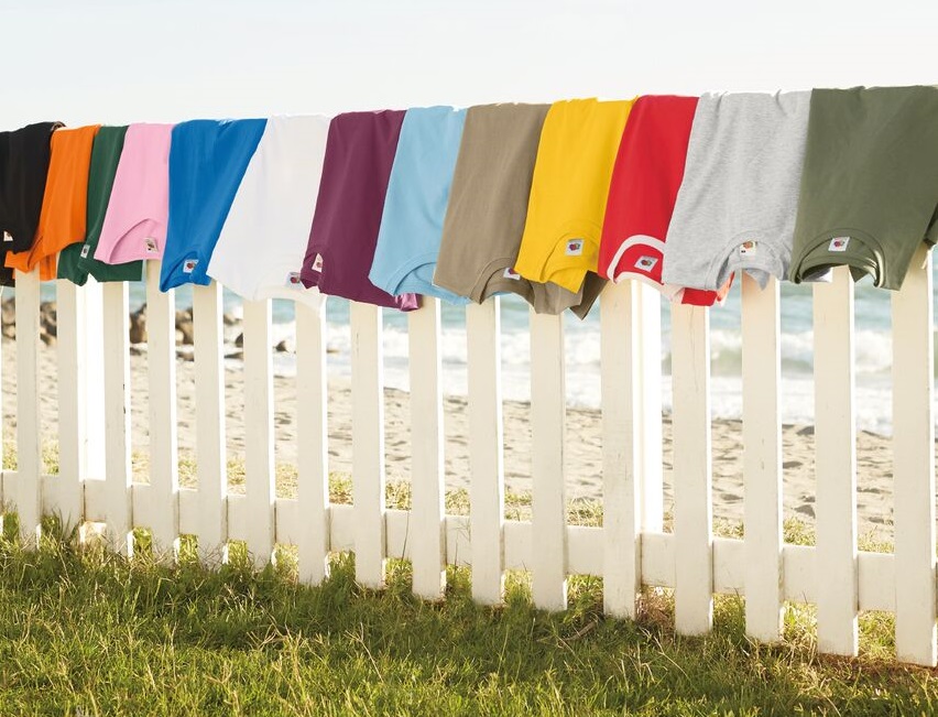 A white fence with Fruit of the loom t shirts resting on top.