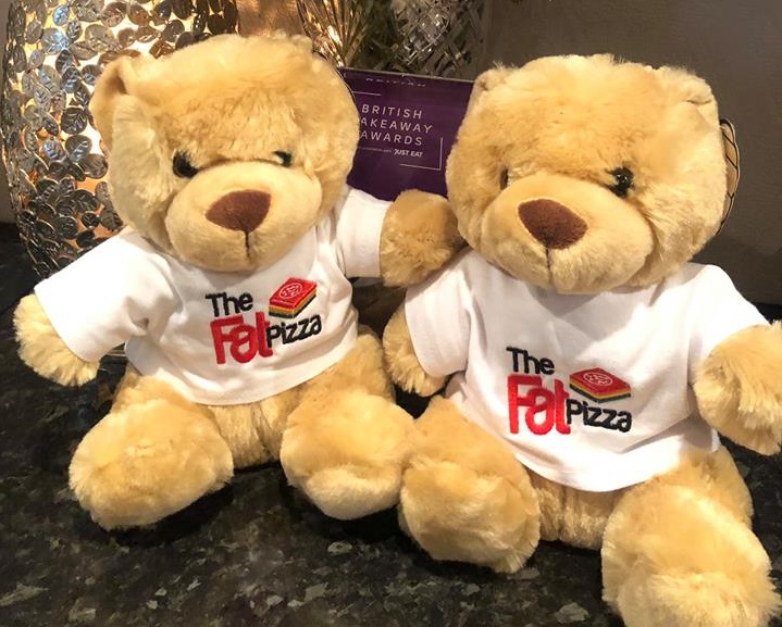 Two teddy bears wearing a t-shirt reading 'the fat pizza'