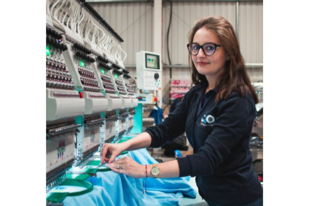 Embroidery team leader operating an embroidery machine