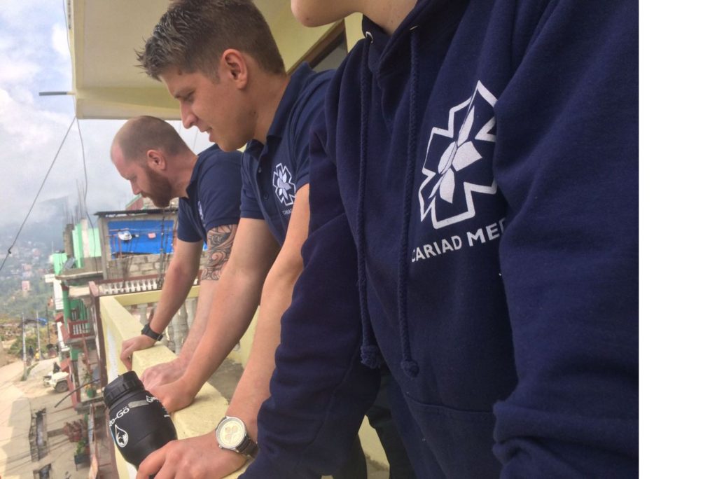 Row of three men in navy uniforms with the Cariad Medic logo.