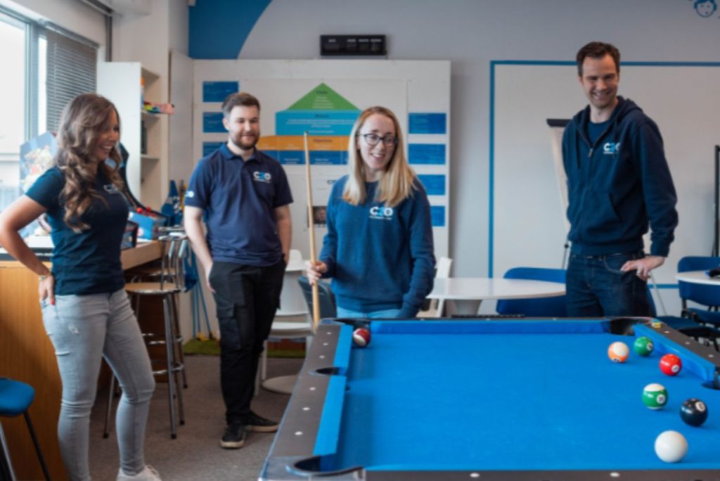 4 members of Clothes2order playing snooker in the Clothes2order team dining area.
